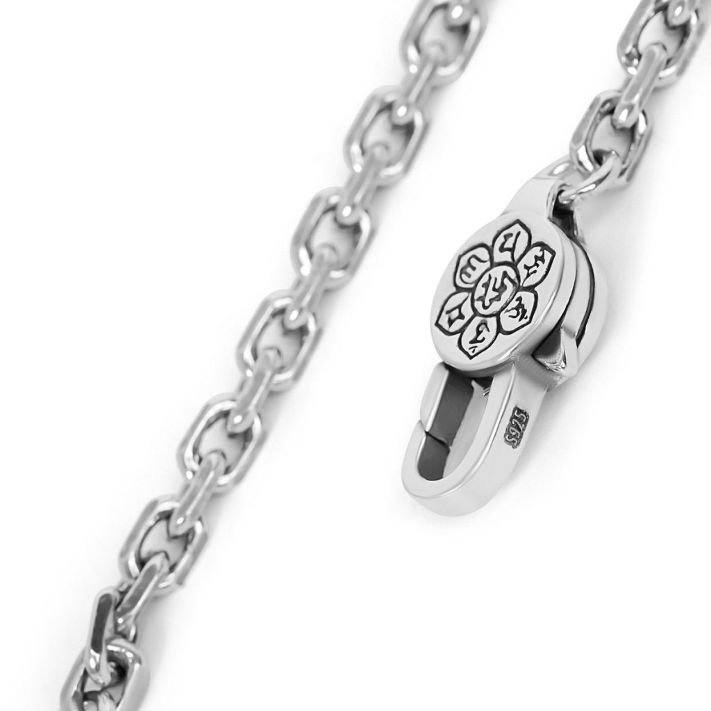 Close-up of the Ronatelli Duomo 4 mm cable chain: polished oval links and a lobster clasp with an engraved flower disc, stamped S925