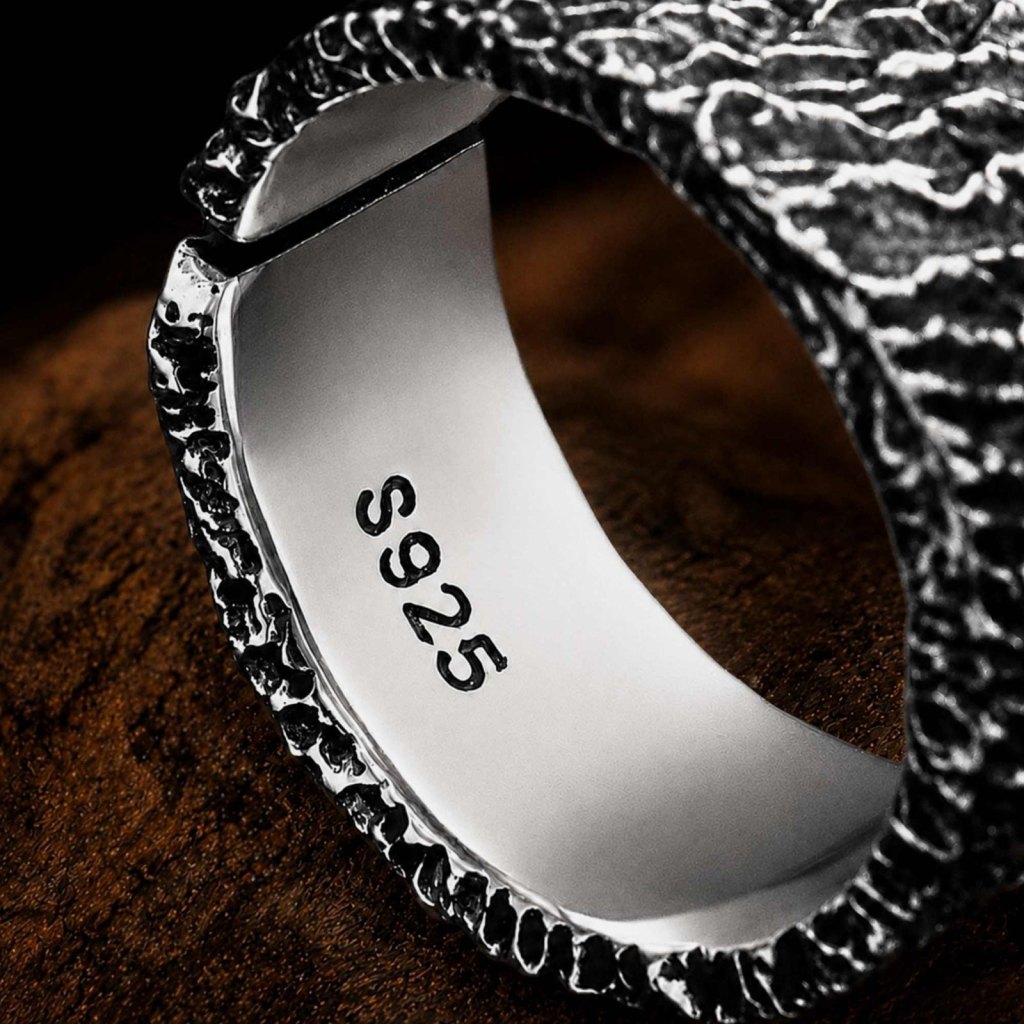 Close-up of the inside of the Ronatelli Etna rock-texture band ring: smooth, polished silver stamped S925, with the opening at the back that makes it adjustable