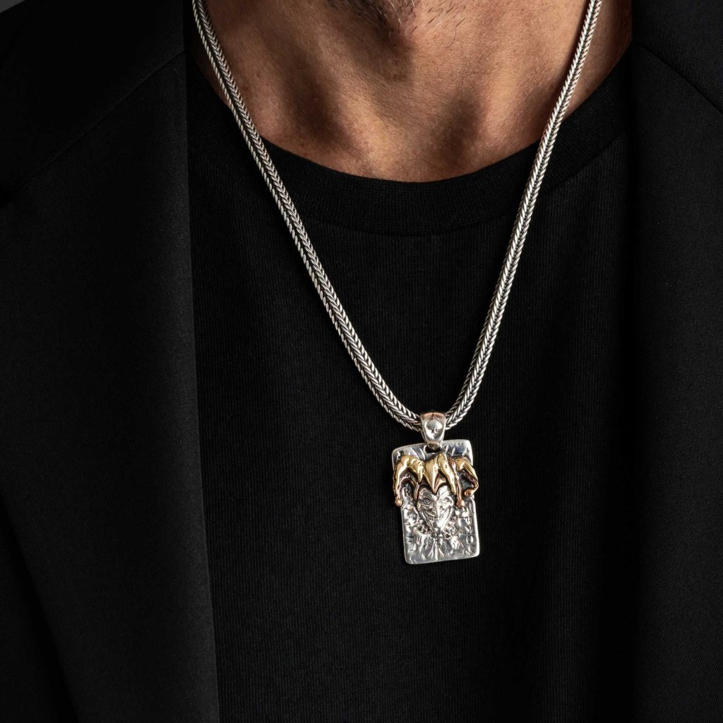 Man in a black T-shirt wearing the Ronatelli Fabro 925 sterling silver joker pendant, a card-shaped plate with a gold-tone jester crown, on a foxtail chain