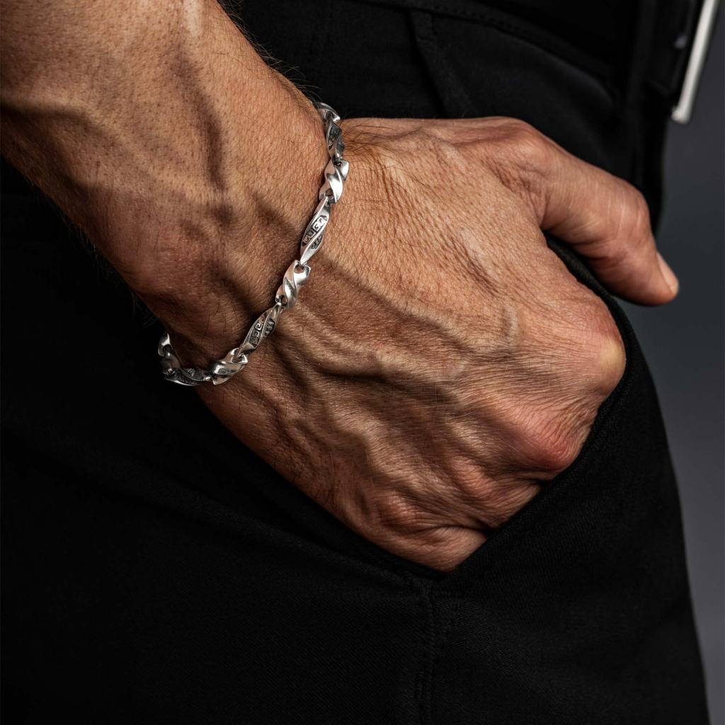 Man wearing the Ronatelli Krun scroll link 925 sterling silver bracelet, hand in his pocket