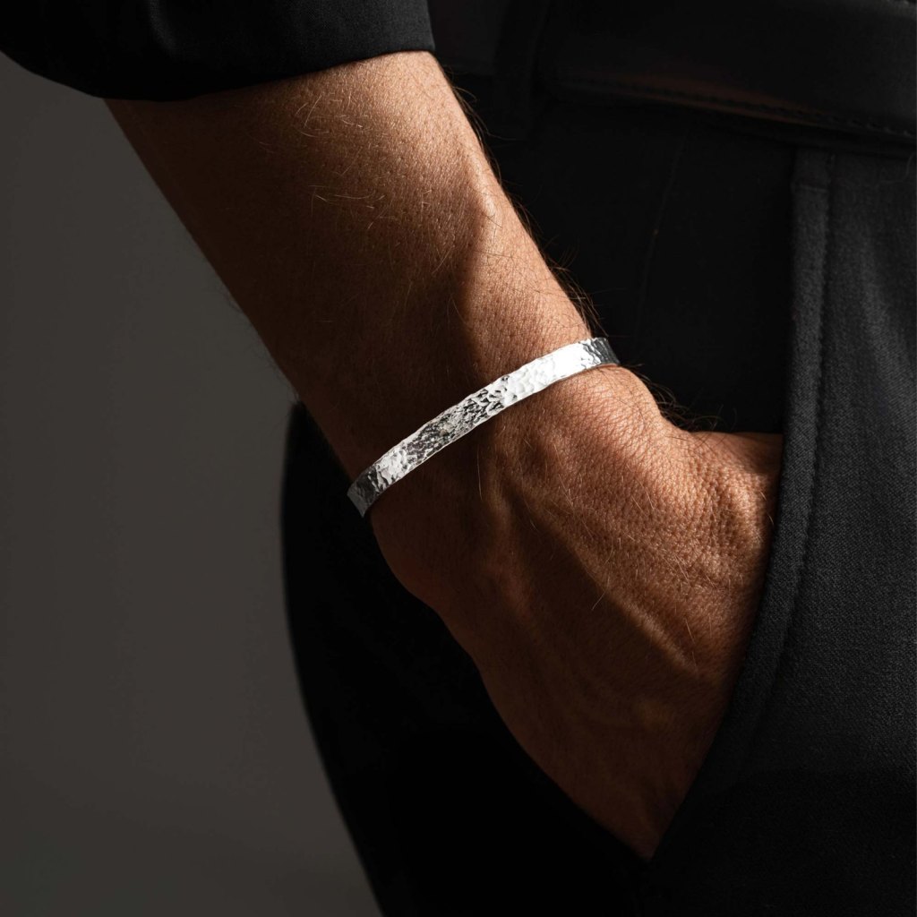 Man with his hand in his pocket wearing the Ronatelli Lugo 6 mm hammered 925 sterling silver cuff bracelet