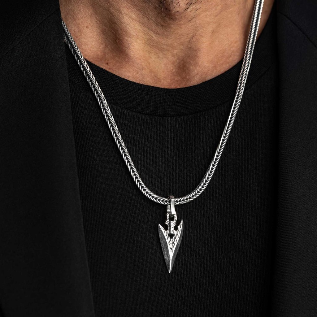 Man in a black T-shirt and jacket wearing the Ronatelli Lyon arrowhead 925 sterling silver pendant on a foxtail chain