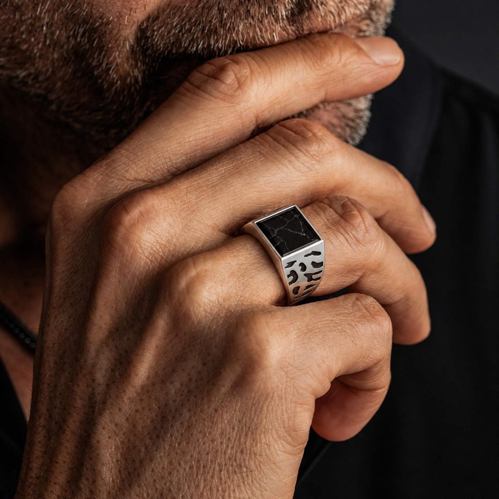 Man resting his chin on his hand, wearing the Ronatelli Marmo 925 sterling silver signet ring with a square black stone