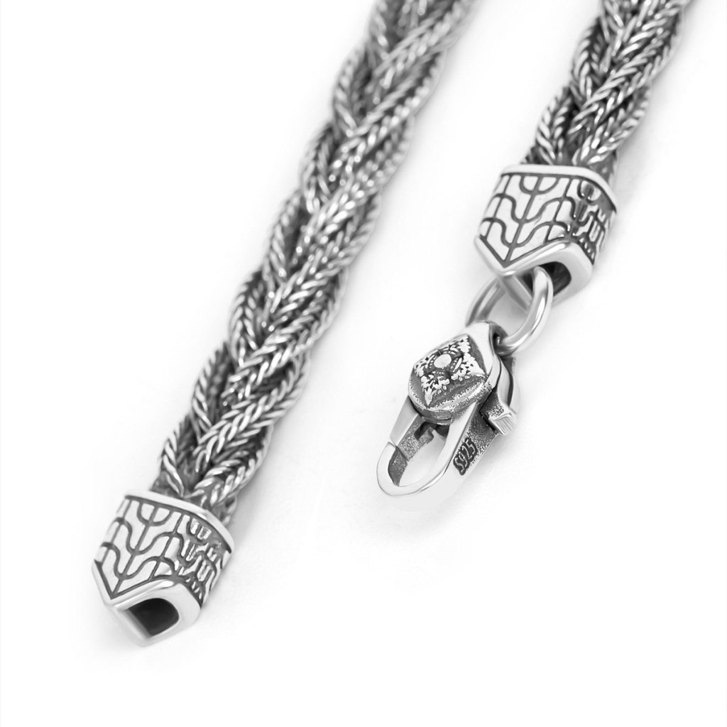 Close-up of the Ronatelli Parma 6 mm twisted foxtail chain: several foxtail strands twisted into one, engraved end caps wider than the chain, and a lobster clasp stamped S925