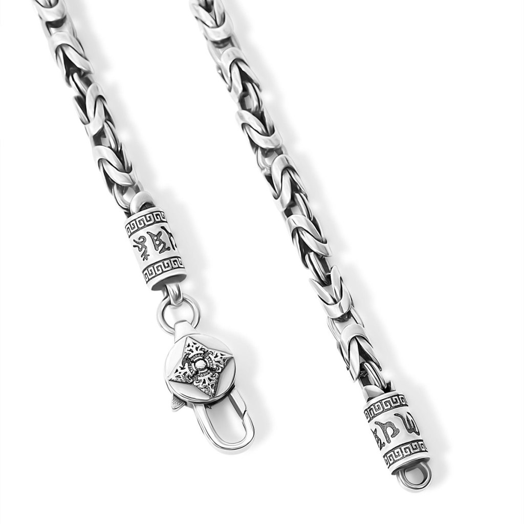 Close-up of the Ronatelli Pudolf 4 mm Byzantine chain in 925 sterling silver: folded ring clusters, engraved end caps, and a lobster clasp with an engraved disc