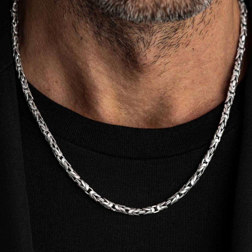 Man with a gray-flecked beard wearing the Ronatelli Pudolf 4 mm Byzantine 925 sterling silver chain over a black T-shirt
