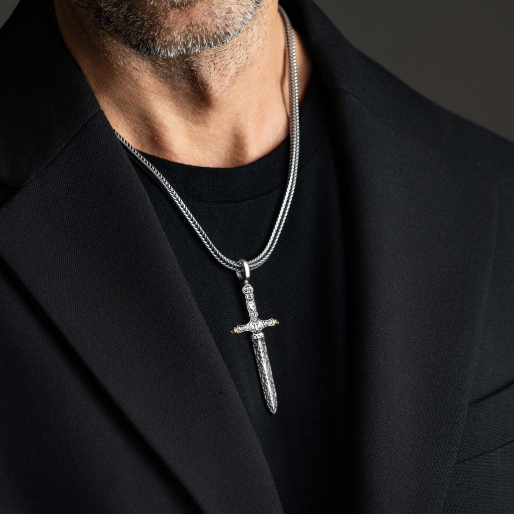 Man in a black T-shirt and jacket wearing the Ronatelli Ravenna cross sword 925 sterling silver pendant on a foxtail chain